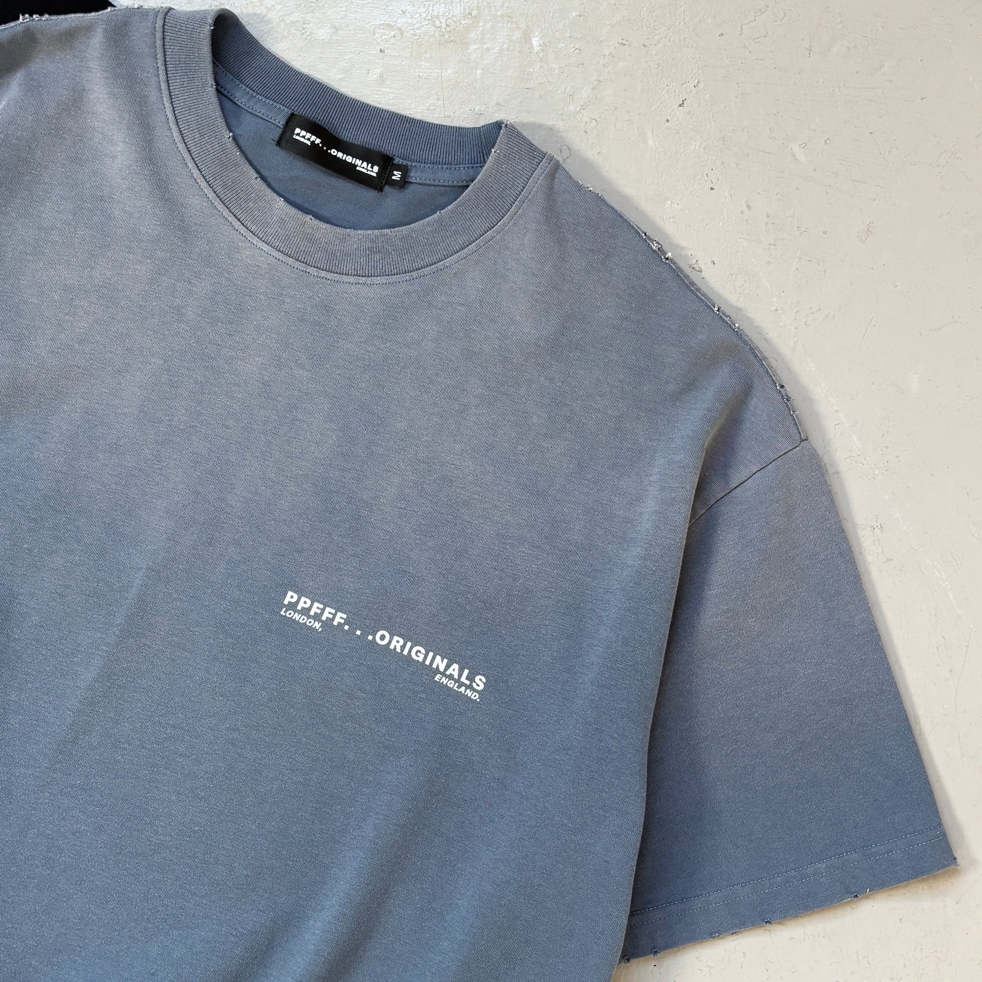 Folded blue sweatshirt with a brand logo on a light background